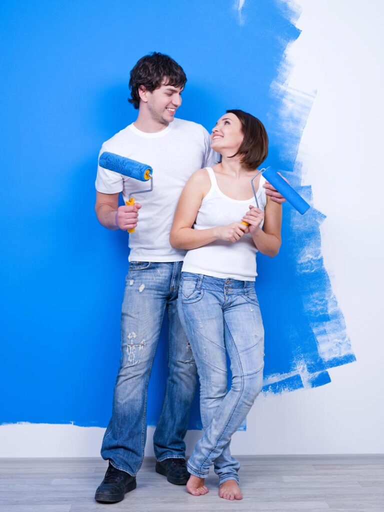 Happy Couple Painting their Interior with Blue Paint