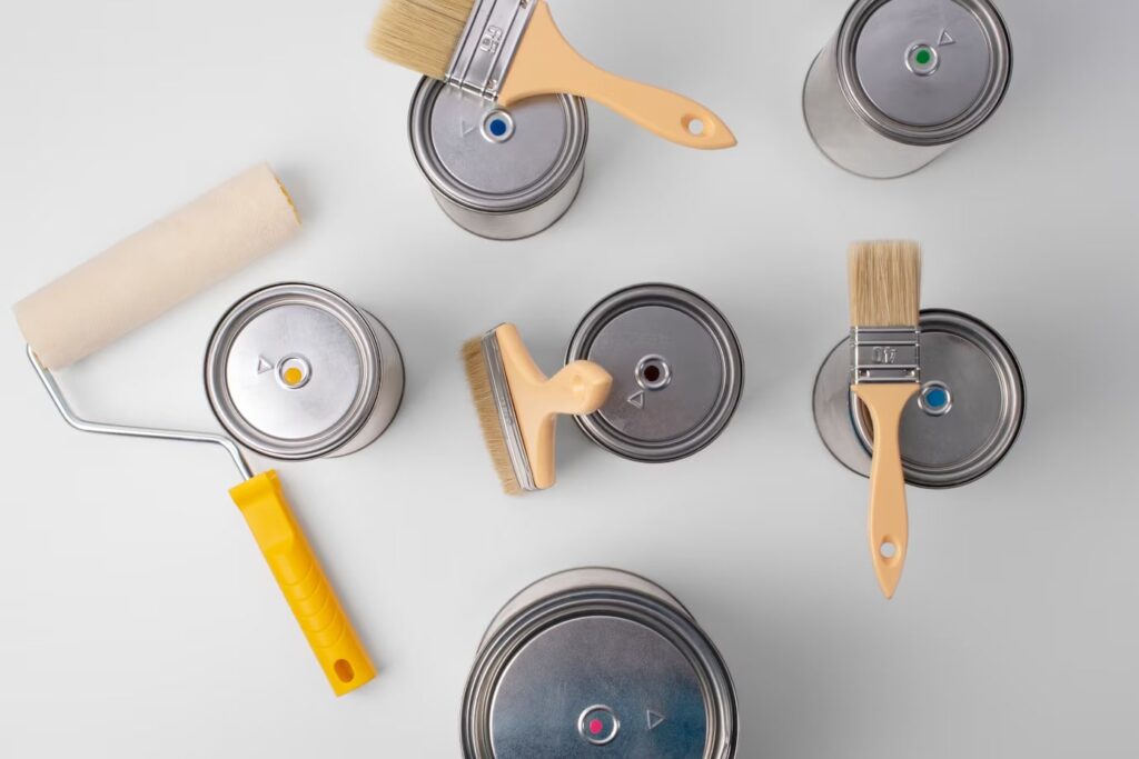 A Top View of Paint Cans, Brush and Paint Rollers