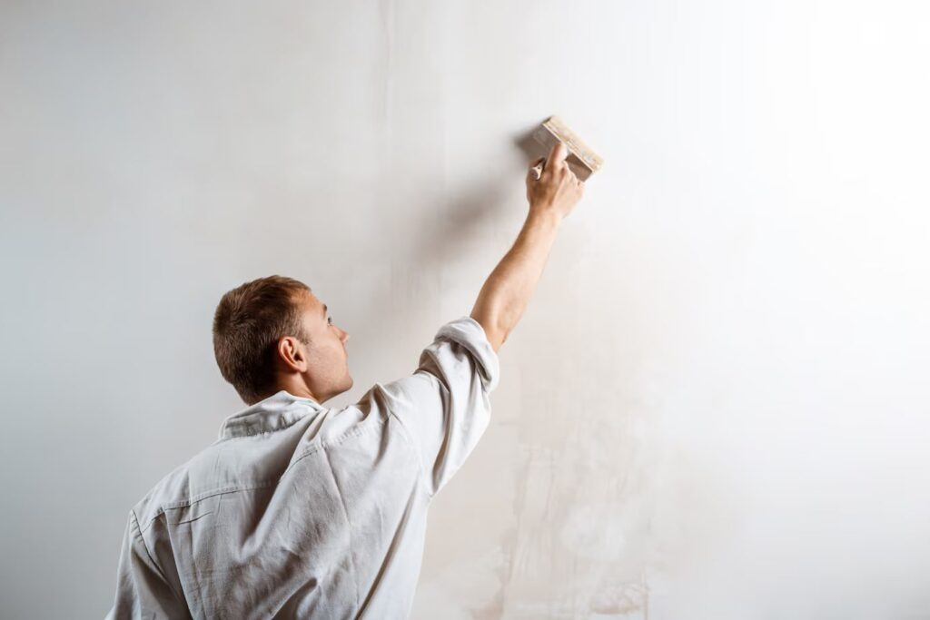 Worker Painting Wall With Brush With White color Paint