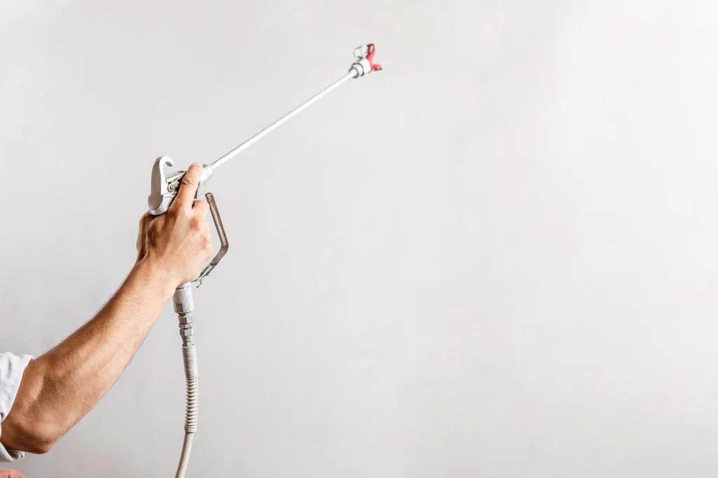 worker-painting-wall-with-spray-gun-white-color