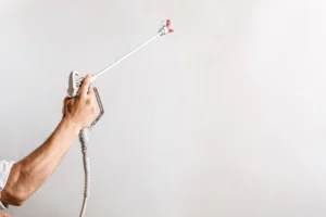 worker-painting-wall-with-spray-gun-white-color