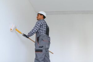 Man paints white wall