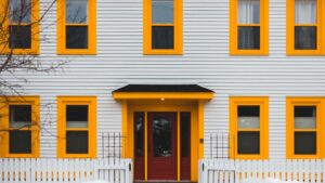 Vibrant house exterior with yellow trim and red door enhancing curb appeal