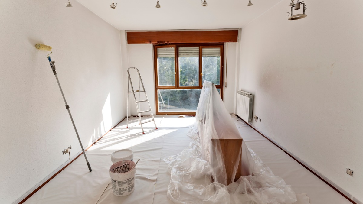 empty room prepared for painting with plastic drop cloths