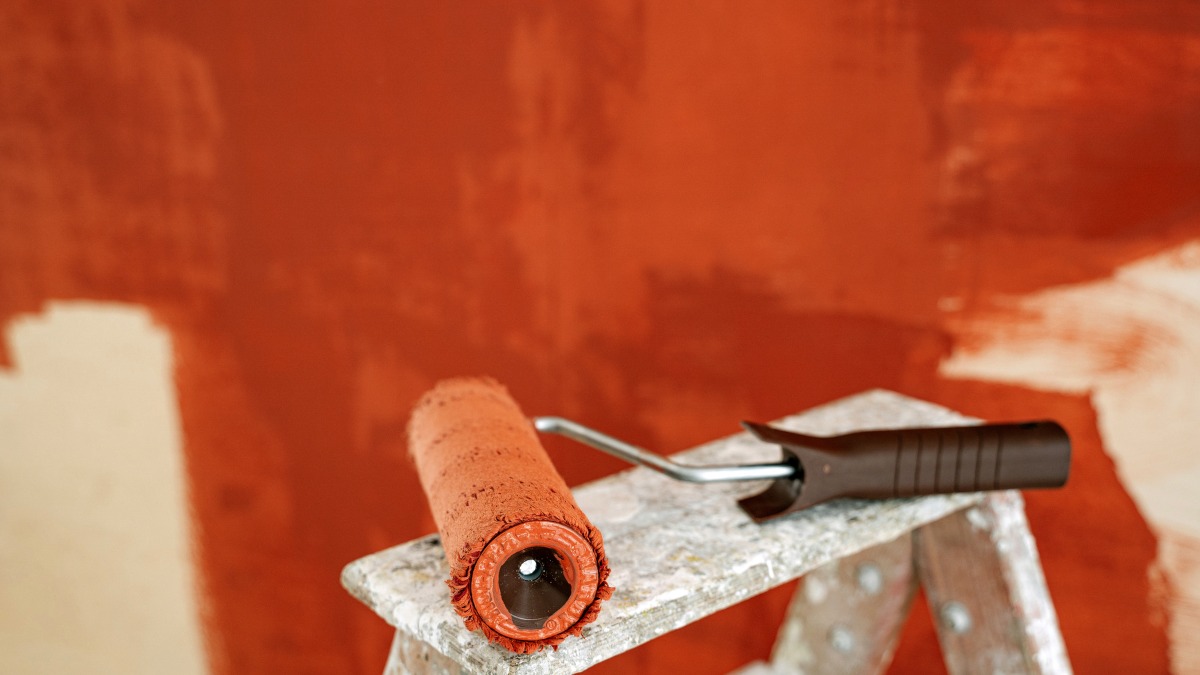 Paint roller covered in reddish-brown paint
