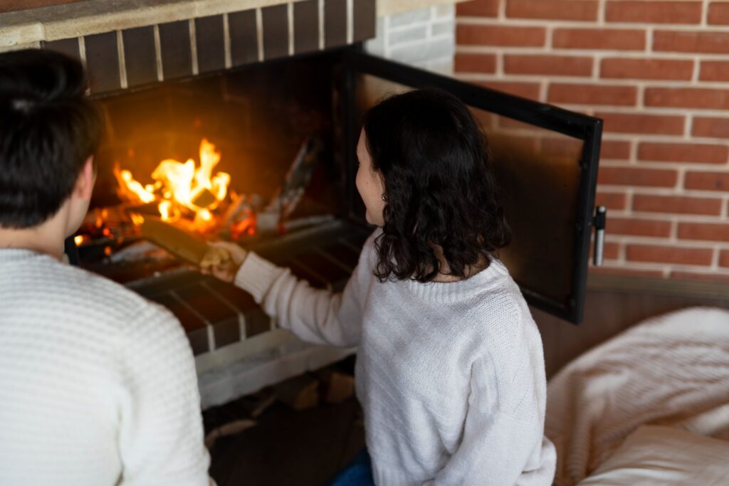 High angle woman putting wood in fireplace