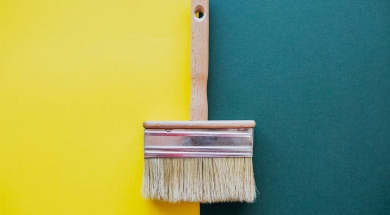 A Brush and a yellow paint on the other side and a green paint on the other
