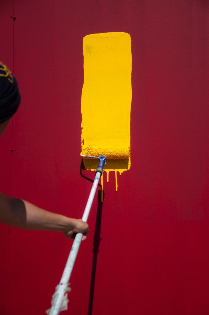 Man Apply Yellow Paint using Paint Roll (1)